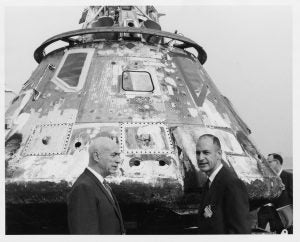 Dr. Robert R. Gilruth and George M. Low in front of Apollo capsule, 1968.