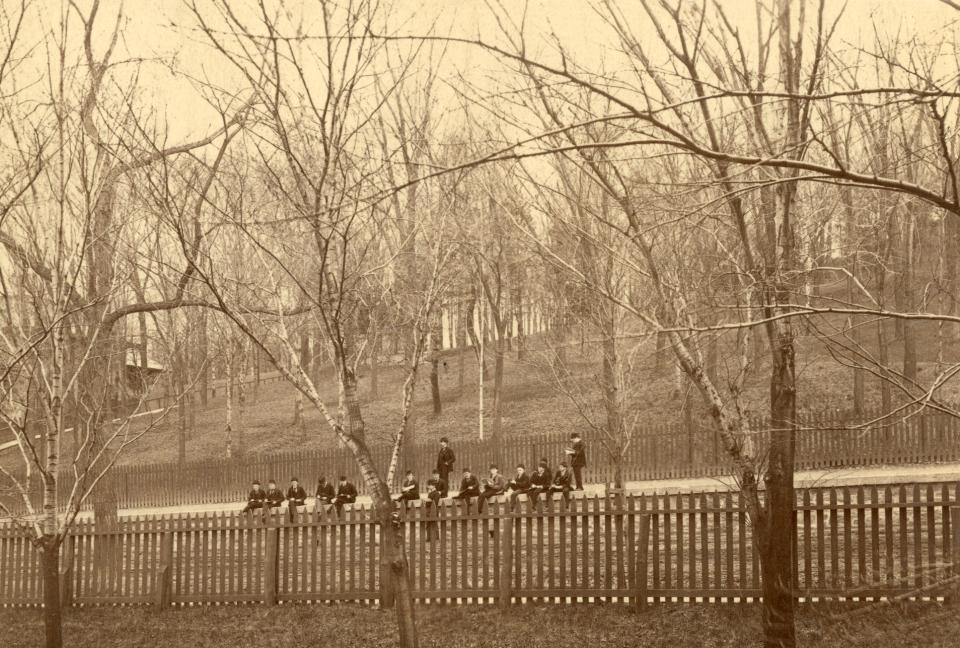 Students sitting on stone wall along 8th Street – Ranken House in the background on the left-hand side.