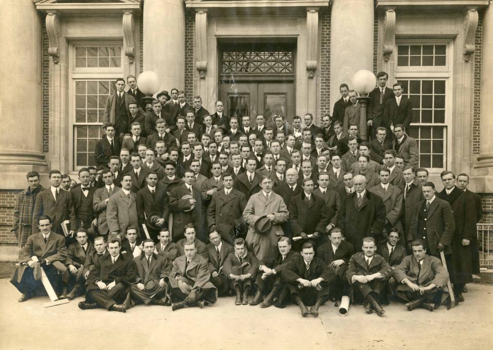 Sepia-toned photo of the Class of 1913 outside of a building