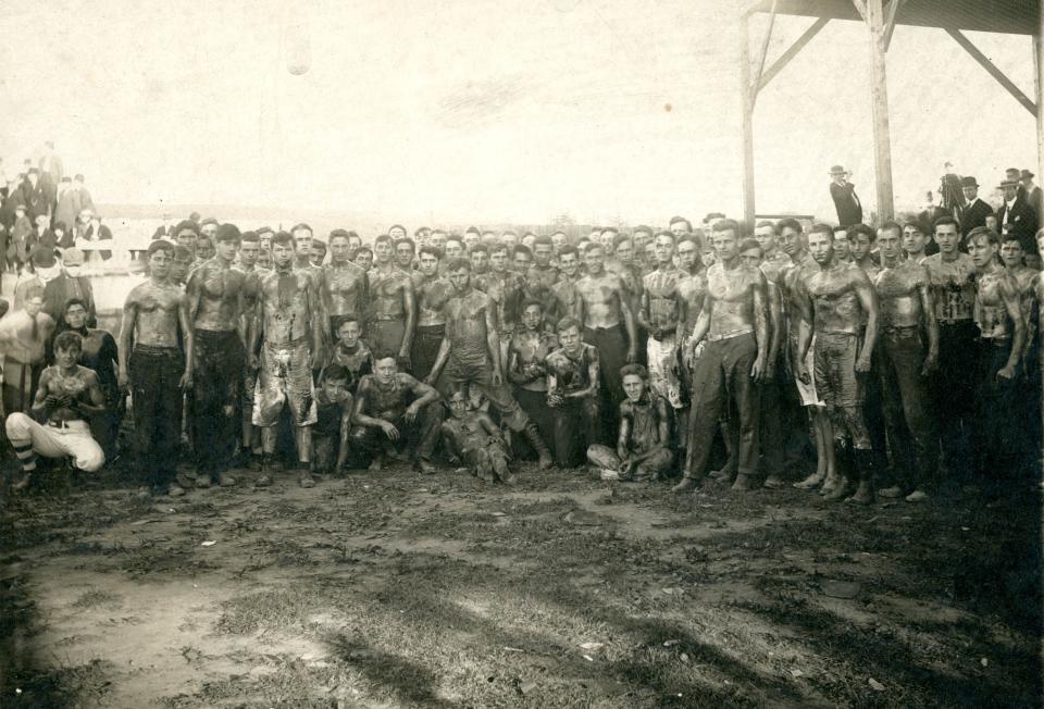 Sepia toned image of the shirtless Class of 1913 after the cane rush