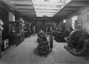 Interior view of the east wing of the Sage Laboratory, depicting students working at some early electrical equipment