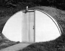 >xterior view of teh entrance to the Seismograph Lab, showing the structure's arched, earth-covered roof (west-southwest elevation, date unknown)